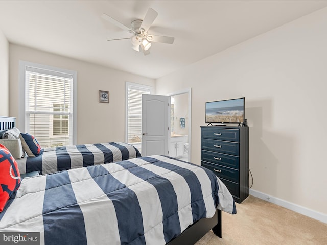 bedroom featuring ceiling fan, ensuite bathroom, and light colored carpet