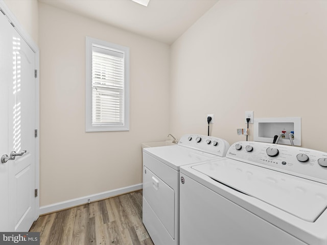 washroom with washing machine and dryer and light hardwood / wood-style flooring