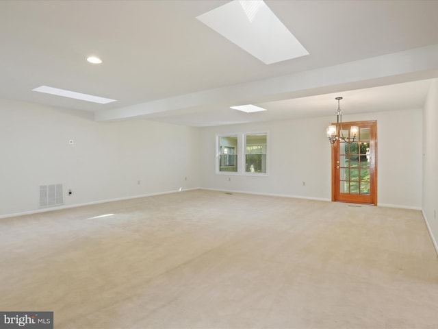 unfurnished room with a notable chandelier and light colored carpet