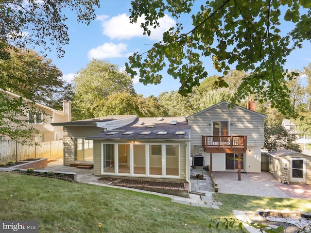 back of house featuring a shed, a yard, a patio, and central AC unit