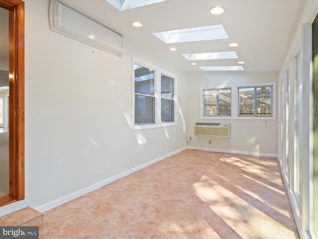 unfurnished sunroom featuring vaulted ceiling with skylight and an AC wall unit