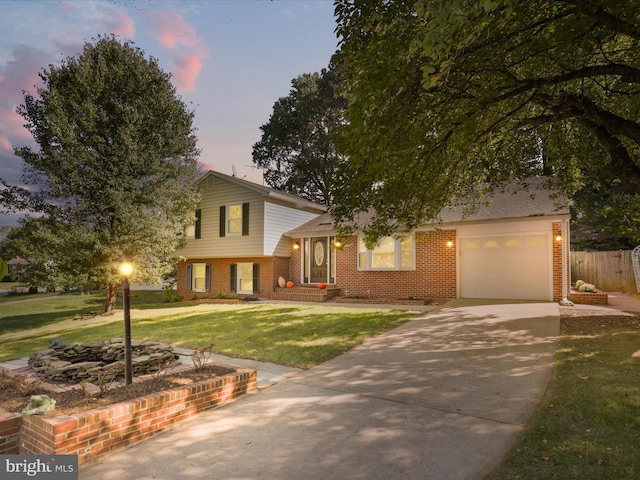 tri-level home featuring a lawn and a garage