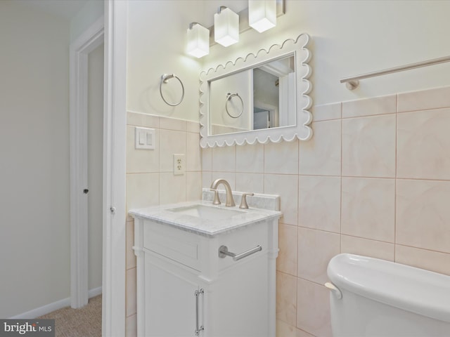 bathroom with vanity, tile walls, and toilet