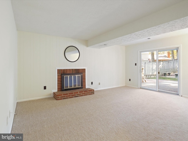 unfurnished living room featuring a fireplace, a textured ceiling, and light colored carpet