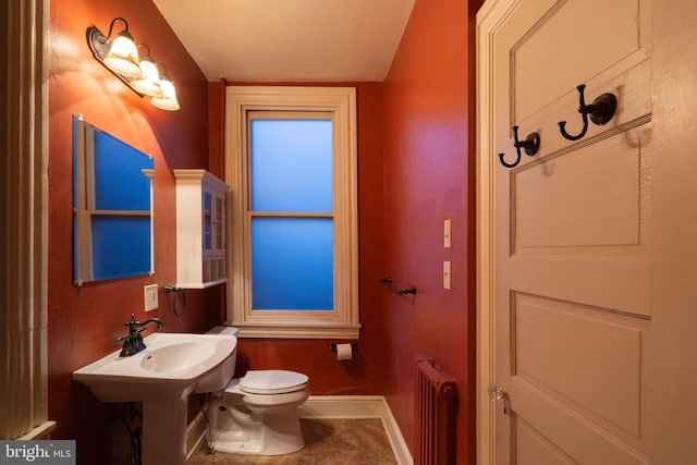 bathroom with tile patterned floors, toilet, and radiator