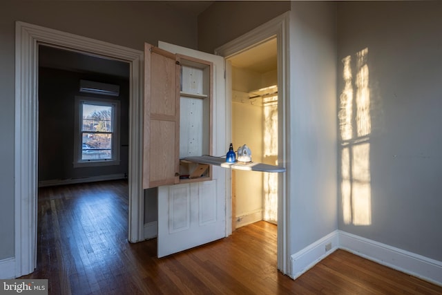 interior space featuring a wall mounted AC and dark wood-type flooring