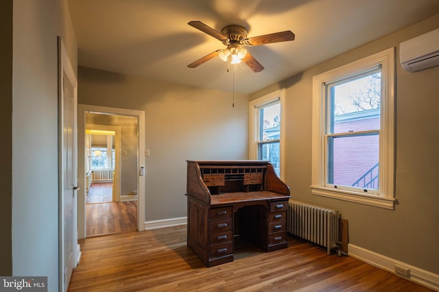 home office featuring ceiling fan, wood-type flooring, radiator, and an AC wall unit