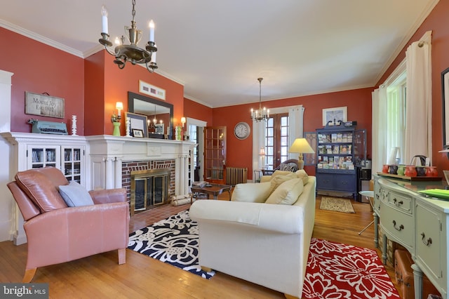 living room featuring light wood-type flooring, crown molding, and a notable chandelier