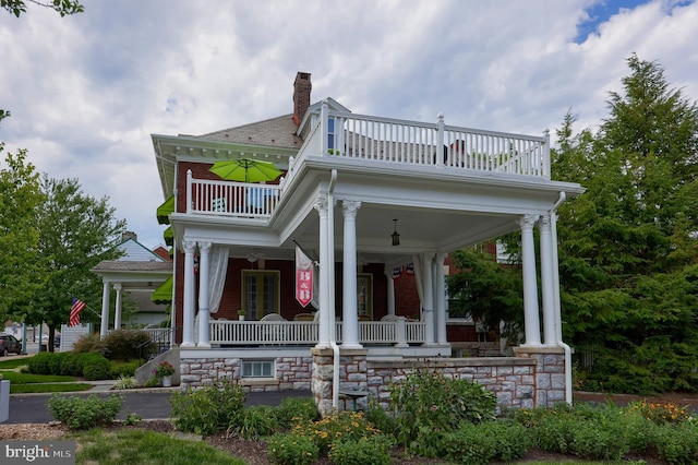 view of front of property with covered porch and a balcony