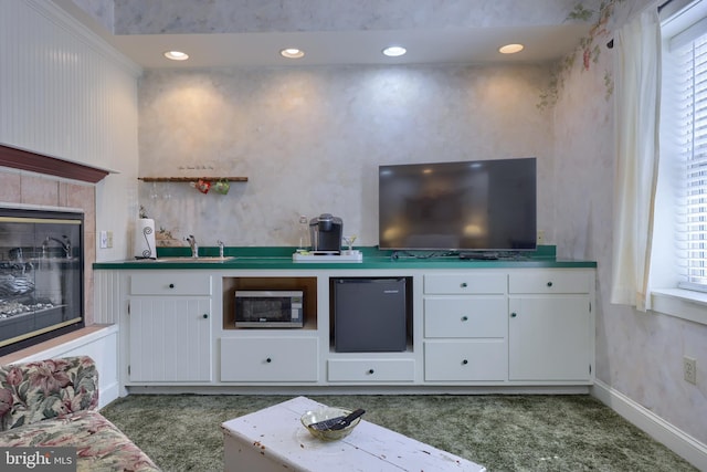 unfurnished living room with sink and dark colored carpet