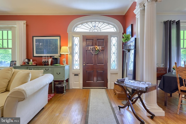 entryway featuring light hardwood / wood-style floors, ornamental molding, and a wealth of natural light