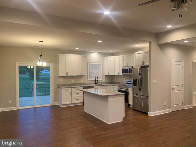 kitchen featuring pendant lighting, a center island, dark wood-type flooring, white cabinetry, and stainless steel appliances