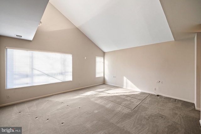 unfurnished living room featuring high vaulted ceiling and carpet