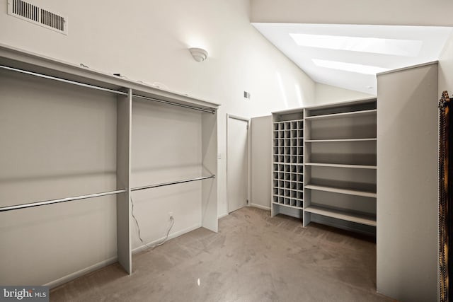 walk in closet featuring light carpet and vaulted ceiling with skylight