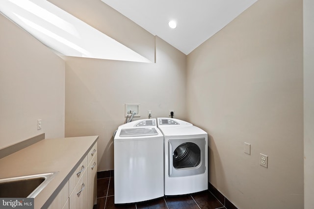 laundry room featuring cabinets, sink, washing machine and clothes dryer, and dark tile patterned flooring