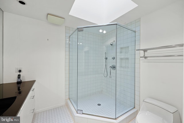 bathroom with a shower with door, vanity, tile patterned flooring, and toilet