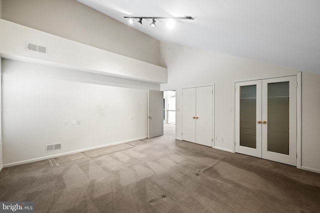 interior space featuring high vaulted ceiling, rail lighting, and french doors