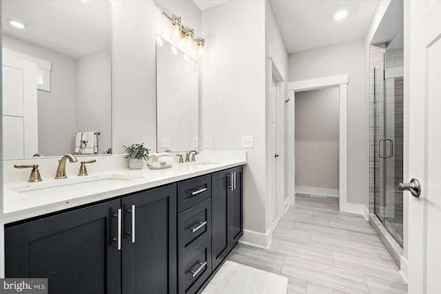 bathroom with a shower with shower door and vanity