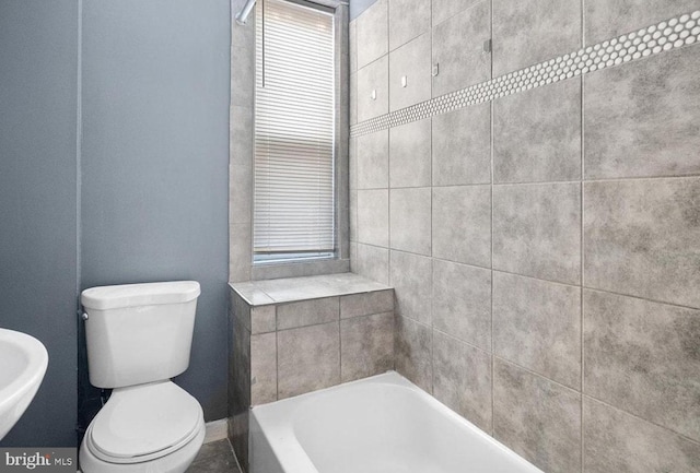 bathroom featuring toilet, sink, and a tub