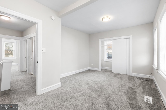 unfurnished room featuring a healthy amount of sunlight and carpet floors