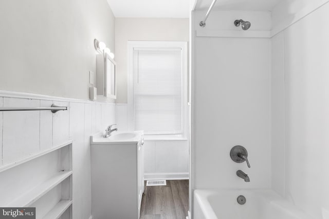 bathroom with shower / bathing tub combination, vanity, and wood-type flooring