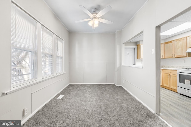 interior space with ceiling fan, crown molding, and light carpet