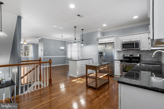 kitchen with white cabinets, stainless steel appliances, hanging light fixtures, and sink