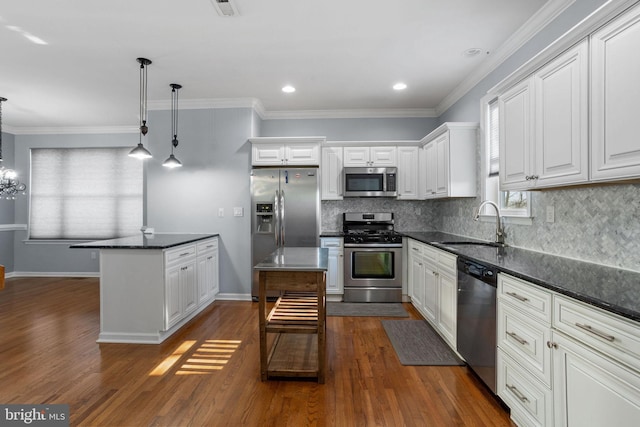 kitchen with white cabinets, stainless steel appliances, hanging light fixtures, and dark hardwood / wood-style floors