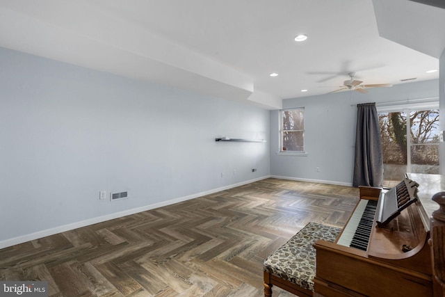 living room featuring dark parquet flooring, plenty of natural light, and ceiling fan