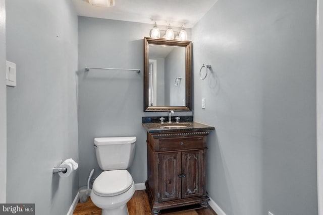 bathroom featuring vanity, wood-type flooring, and toilet