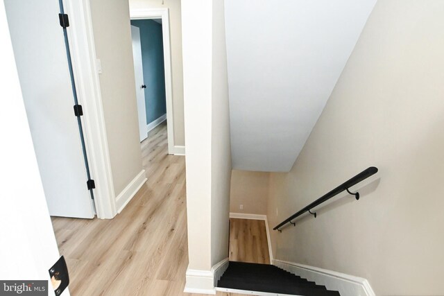 stairs featuring wood finished floors and baseboards