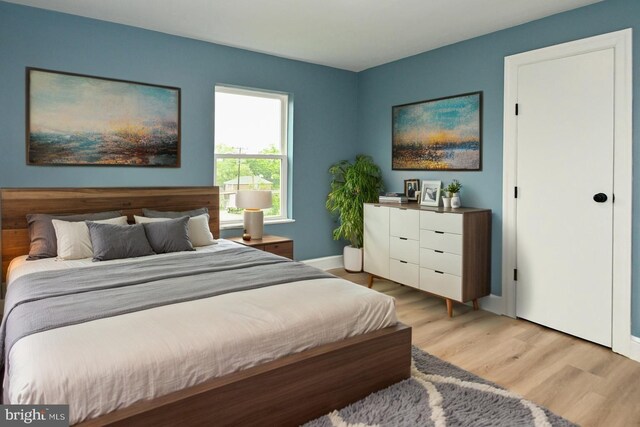 bedroom with light wood-style flooring and baseboards
