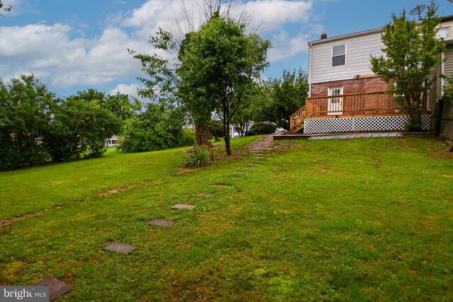 view of grassy yard with a deck