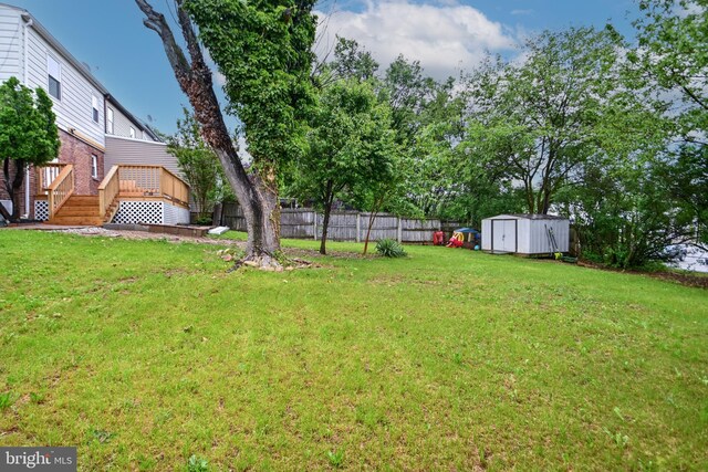 view of yard with a storage shed, an outdoor structure, and a deck