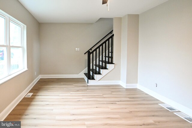 entrance foyer with wood finished floors, ceiling fan, baseboards, and stairway