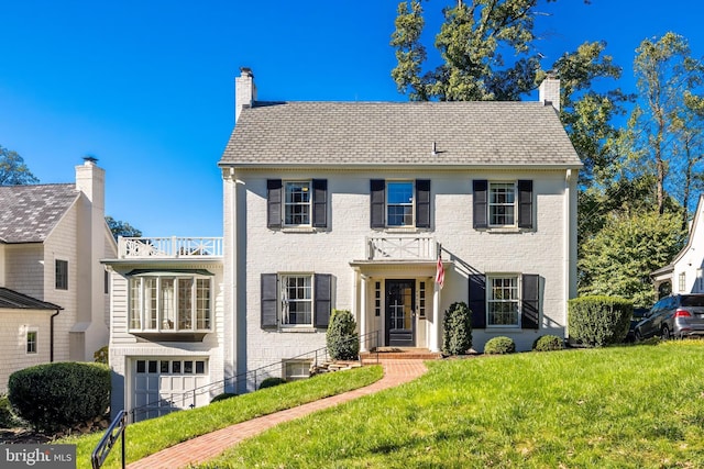 colonial home featuring a front lawn and a garage