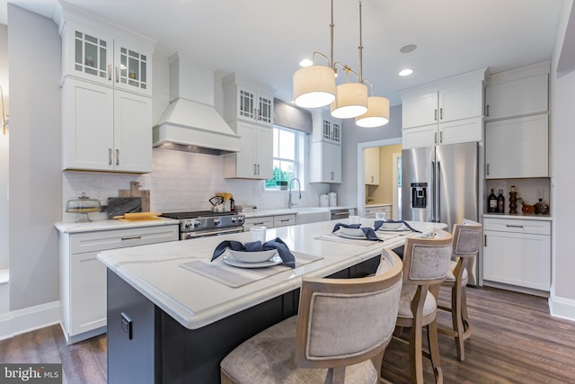 kitchen featuring a center island, dark hardwood / wood-style flooring, white cabinets, custom range hood, and appliances with stainless steel finishes