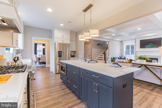 kitchen with dark hardwood / wood-style flooring, high end appliances, decorative light fixtures, white cabinets, and a center island