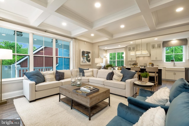 living room with beam ceiling, light wood-type flooring, and coffered ceiling