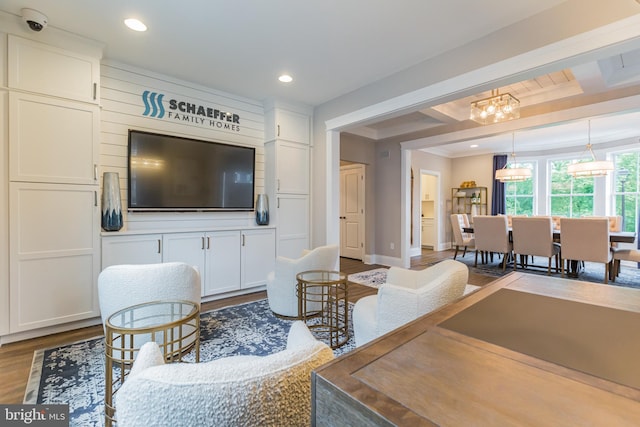 living room with hardwood / wood-style floors, beamed ceiling, and an inviting chandelier