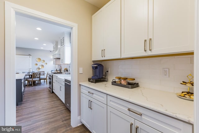 kitchen featuring light stone countertops, white cabinetry, stainless steel appliances, tasteful backsplash, and dark hardwood / wood-style flooring