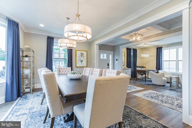 dining room with beam ceiling, wood-type flooring, crown molding, and an inviting chandelier