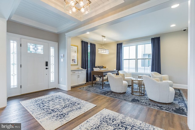 entrance foyer with ornamental molding, dark hardwood / wood-style floors, and a tray ceiling