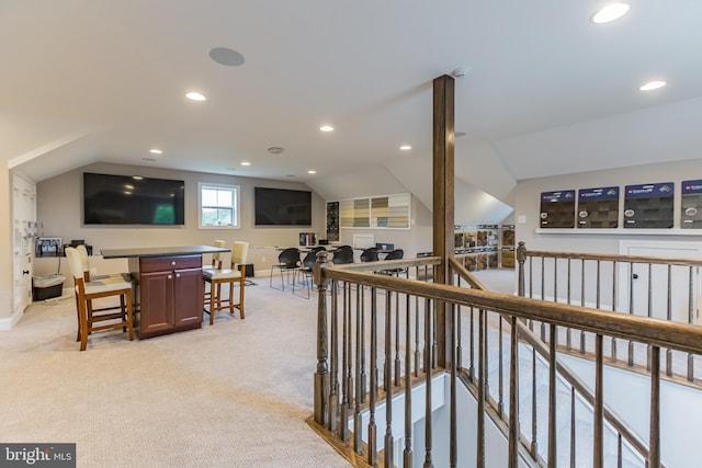 hallway featuring light colored carpet and vaulted ceiling