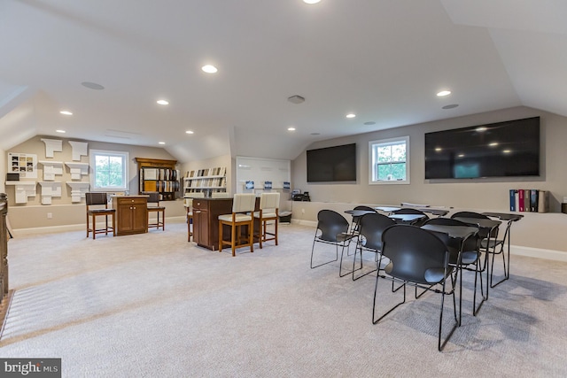 dining area featuring light carpet and vaulted ceiling