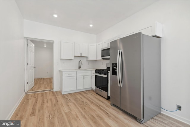 kitchen featuring white cabinets, light hardwood / wood-style floors, sink, and appliances with stainless steel finishes