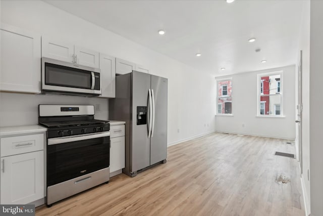 kitchen featuring light wood-type flooring, white cabinetry, and stainless steel appliances