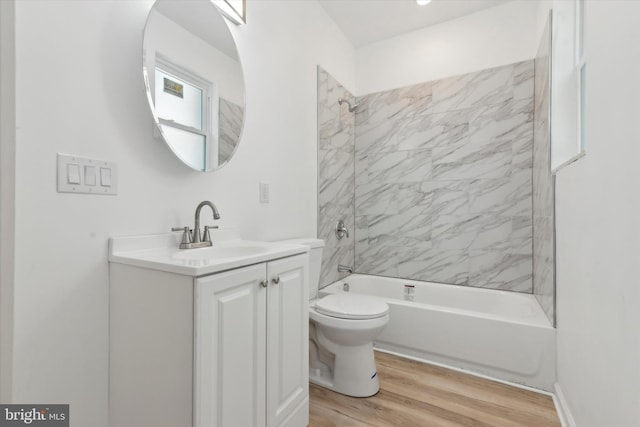 full bathroom featuring vanity, wood-type flooring, tiled shower / bath combo, and toilet