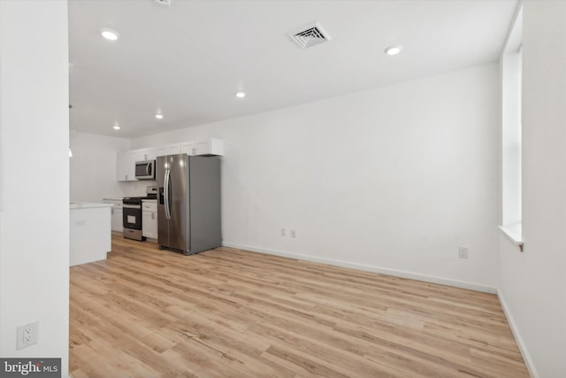 kitchen with white cabinetry, light hardwood / wood-style flooring, and appliances with stainless steel finishes