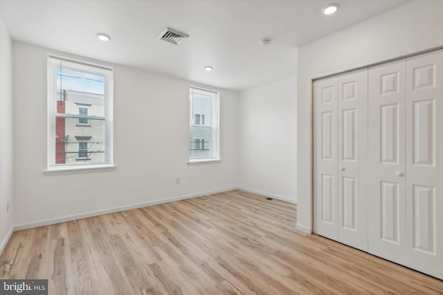 unfurnished bedroom with a closet and light hardwood / wood-style flooring